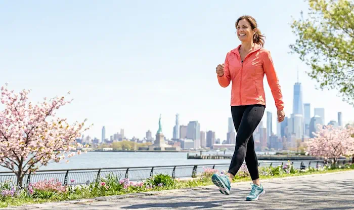Woman walking outdoors in spring near the New Jersey waterfront after vein treatment at Vein Treatment Centers of NJ